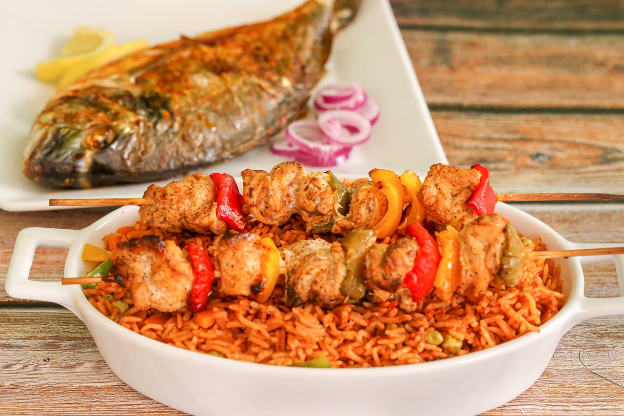 Crafting Captivating Headlines: Your awesome post title goes here Close-up of flavorful Nigerian jollof rice with grilled chicken skewers and roasted fish.